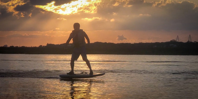 Guy E-Foiling in a Sunset scene