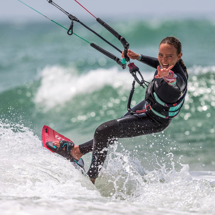 Kiteboarder riding waves with a North Standard short kite safety leash