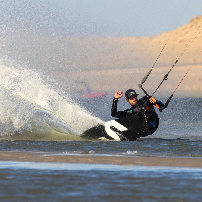 Kiteboarder riding the Slingshot Era V1 twin tip through spray