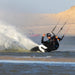 Kiteboarder riding the Slingshot Era V1 twin tip through spray