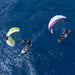 Two paragliders flying over a blue ocean with duotone stash parawing