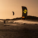 Kitesurfer on a beach with Code NXT v2 sail during sunset.